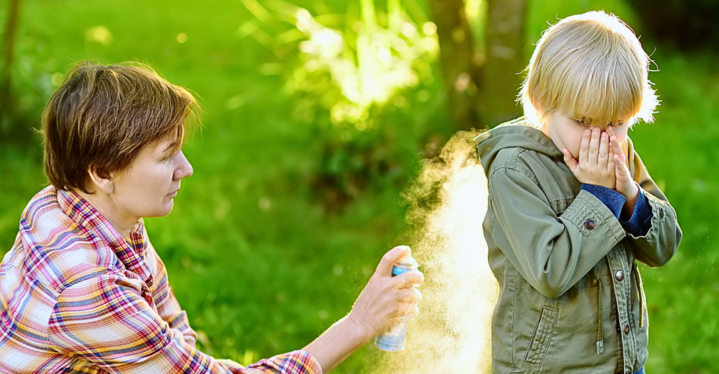 Mother applies mosquito repellent to child